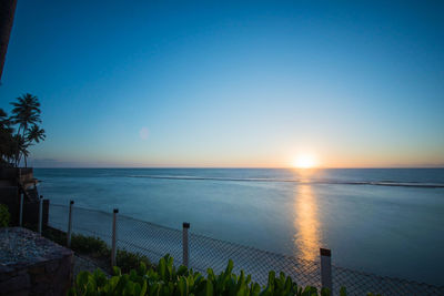 Scenic view of sea against clear sky at sunset