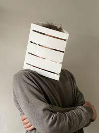 Portrait of a person standing against wall