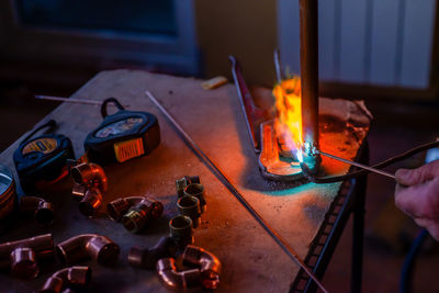 A worker welds copper pipes with a gas torch for central heating