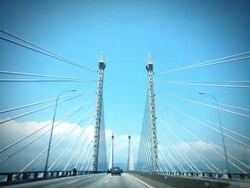 View of suspension bridge against blue sky