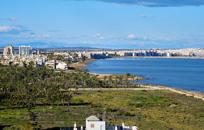 Scenic view of sea by buildings against sky