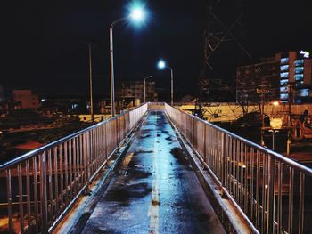 Illuminated street amidst buildings at night