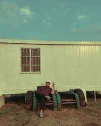 Side view of woman sitting on grassy field