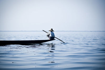 Man standing in sea against clear sky