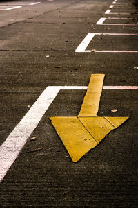 Yellow arrow symbol on concrete road.