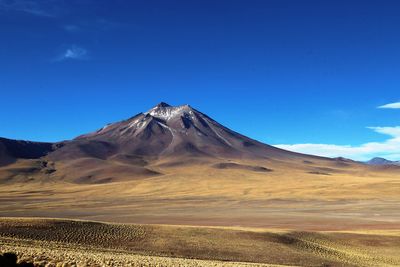 Scenic view of volcanic landscape against blue sky