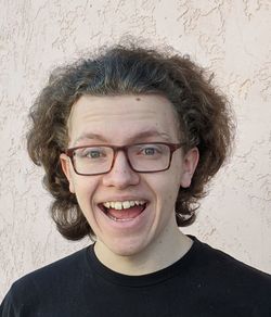 Portrait of smiling young man against wall