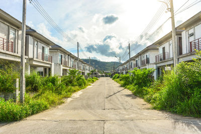 Footpath amidst buildings against sky
