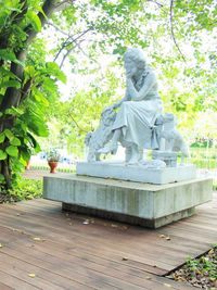 Statue of man sitting on plant