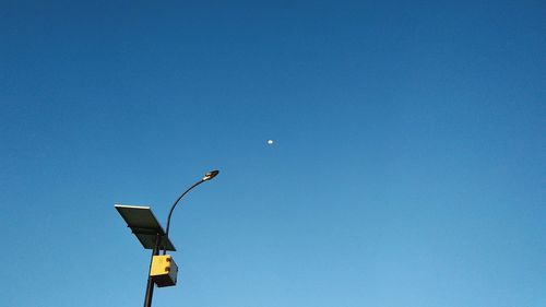 Low angle view of street light against blue sky