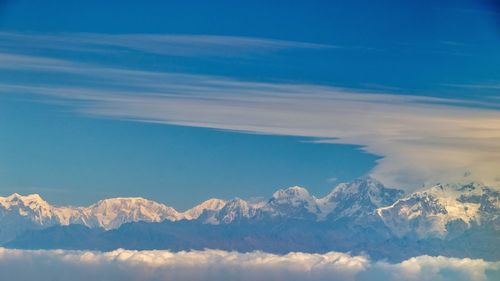 Scenic view of snowcapped mountains against blue sky