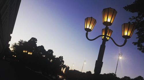 Low angle view of illuminated street light against sky