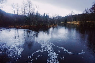 Scenic view of lake against sky during winter