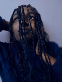 Close-up portrait of a young woman covering face