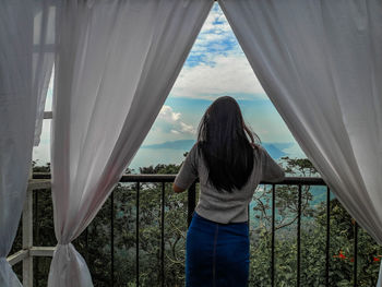 Rear view of teenage girl standing at balcony