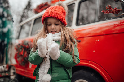 Portrait of young woman sitting on car