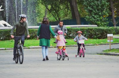 Rear view of people riding bicycle