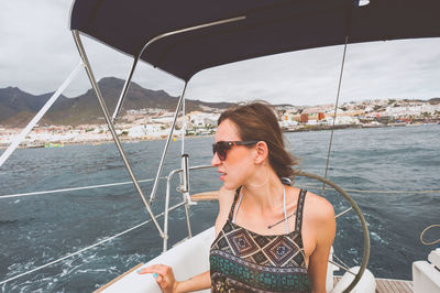 Young woman sitting in boat on sea