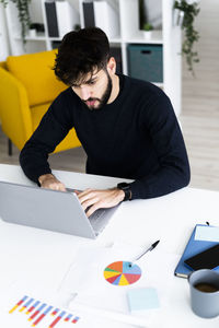 Rear view of man working on table