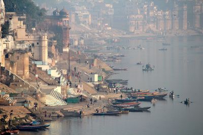 Boats on ganges river by historic temples