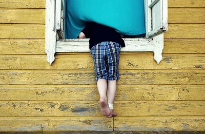 Low section of woman standing on wooden wall