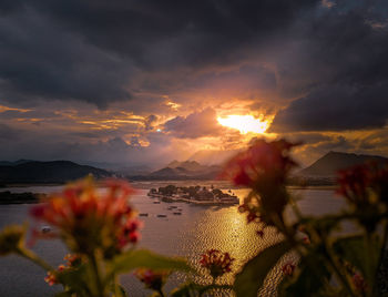 Scenic view of sea against dramatic sky during sunset