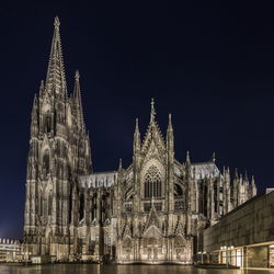 Low angle view of cologne cathedral against clear sky at night