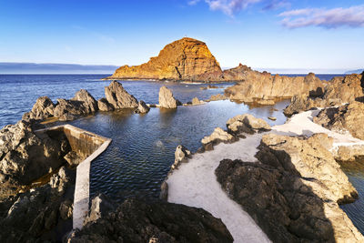 Rocks on beach against sky