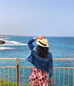 Rear view of woman looking at sea against sky