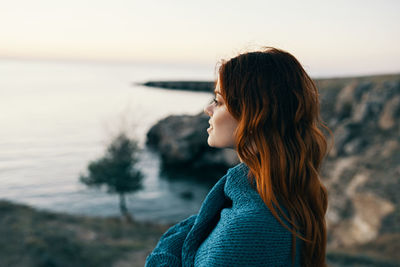 Portrait of woman standing on beach against sky during sunset