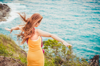 Rear view of woman standing against river