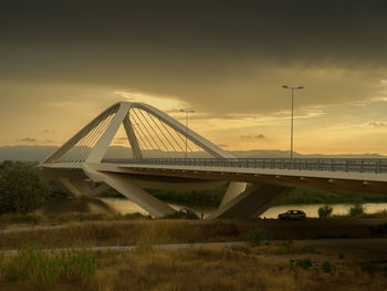 Bridge over landscape against sky during sunset