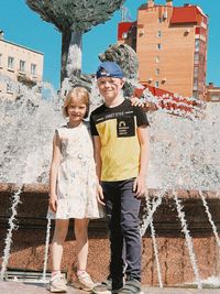 Portrait of smiling couple standing against built structures