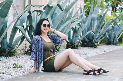 Portrait of young happy brunette asian woman relaxing in city, park. summer vacation. travel