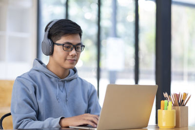 Young collage student using computer and mobile device studying