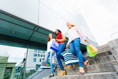 Low angle view of women walking on built structure