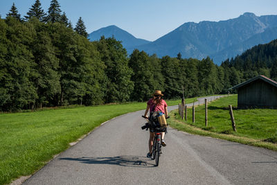 Full length of man riding bicycle on road