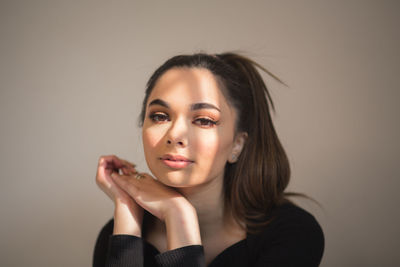 Portrait of young woman against wall