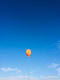 Low angle view of balloons against blue sky