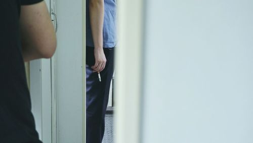 Low section of man standing by door