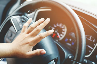 Cropped hand of man driving car