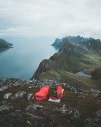 Man lying on mountain against sea