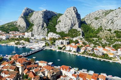 High angle view of townscape by sea against sky