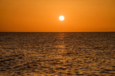 Scenic view of sea against orange sky