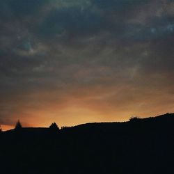 Silhouette of trees against dramatic sky