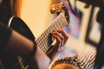 Midsection of man playing guitar