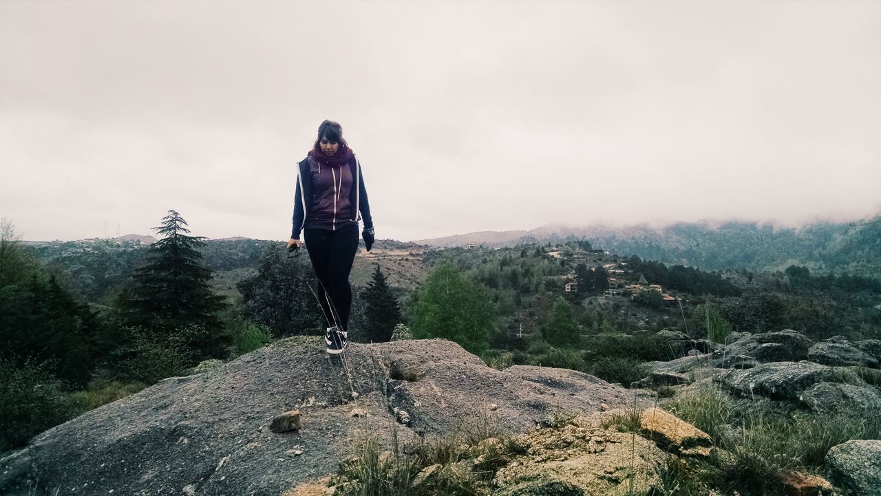 lifestyles, leisure activity, full length, sky, mountain, landscape, casual clothing, tranquility, hiking, tranquil scene, nature, standing, scenics, men, rock - object, rear view, adventure, young adult