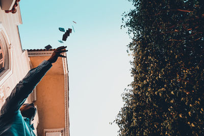 Low angle view of man throwing playing cards