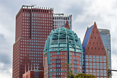 Low angle view of buildings against cloudy sky