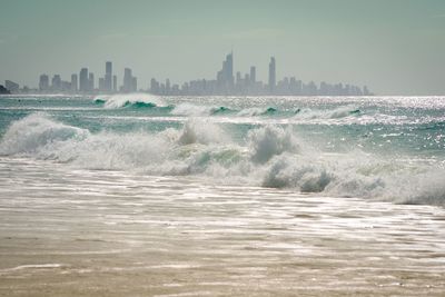 Waves splashing on sea against buildings in city
